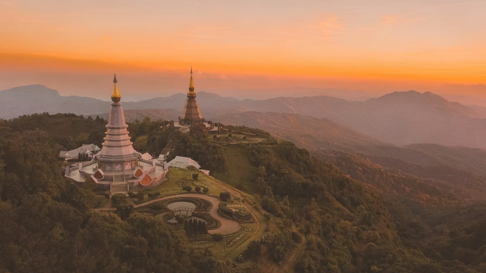 Twin royal pagodas on forested Doi Inthanon ridges at sunset
